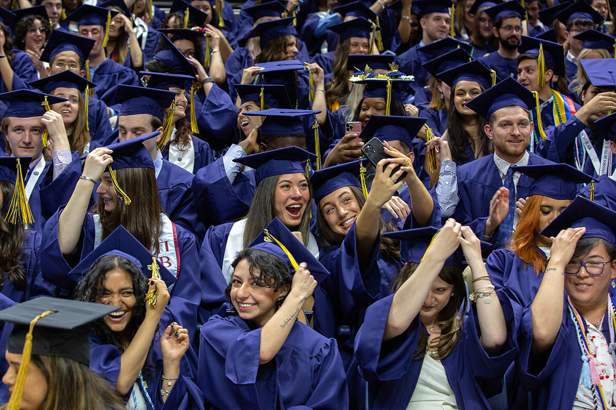 Students move their tassels at the College of Liberal Arts and Sciences (CLAS) Commencement ceremony.